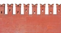 A fragment of red brick wall with a dovetail-shaped merlon battlement, isolated on a white background Royalty Free Stock Photo