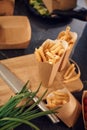 Close up view of French fries that are in the paper eco box. Green onion and knive on the table