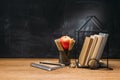 close up view of fresh apple magnifying glass notebook and books on wooden surface with empty Royalty Free Stock Photo