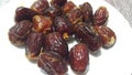Close up view of fresh dried date palm served in ceramic small white plate Royalty Free Stock Photo