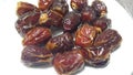 Close up view of fresh dried date palm served in ceramic small white plate Royalty Free Stock Photo