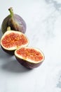 Close up view on Fresh figs. Exotic fruit. Sliced fig on craft paper on marble background. Copy space. Selective focus. Food photo Royalty Free Stock Photo