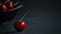 Close up view of fresh fruit sweet ripe cherry in dark light and black background with water droplets low key still life Royalty Free Stock Photo