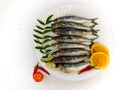 Fresh Indian oil sardine on a white plate,Decorated with herbs and Vegetables.White Background Royalty Free Stock Photo