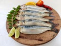 Close up view of Fresh Indian oil sardine on a wooden pad,Decorated with herbs and Vegetables. Royalty Free Stock Photo