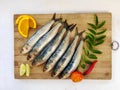 Close up view of Fresh Indian oil sardine on a wooden pad,Decorated with herbs and Vegetables. Royalty Free Stock Photo