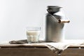 Fresh milk in glass and can on sackcloth on wooden table Royalty Free Stock Photo