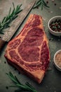 Close up view of fresh red meat with bowls of salt and pepper and rosemary