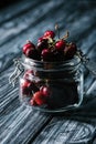 close-up view of fresh ripe cherries in glass jar on rustic Royalty Free Stock Photo