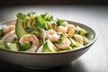 A close-up view of a fresh shrimp and avocado salad served on a plate.