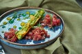 Close up view on fresh tuna tartare with bread, onion in blue plate on wooden background. Restaurant food. selective focus