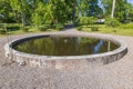 Close up view of garden landscape design with round decorative outdoor pond with fishes. Royalty Free Stock Photo