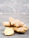 Ginger slice and ginger root on gray background