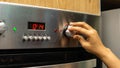 Close up view of girl hand setting up the desire temperature for baking at the kitchen