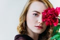 close-up view of girl holding red flower and looking at camera Royalty Free Stock Photo