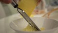 Close-up view of girl on the kitchen rubs cheese on the grater