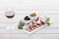 Close up view of glass of red wine, olives and assorted meat snacks Royalty Free Stock Photo