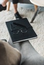 Close-up view of glasses on notebook in front of woman Royalty Free Stock Photo