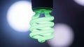 A close-up view of a glowing green spiral light bulb Royalty Free Stock Photo