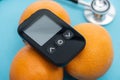 Close up view of glucometer on oranges with stethoscope Royalty Free Stock Photo