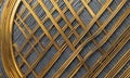 close-up view gold-colored metal lattice structure, with blurred background similar lattice pattern.
