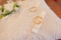 Close-up view of golden wedding rings on decorative white lace pillow. Royalty Free Stock Photo