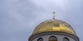 Close-up view of golden yellow dome of church with orthodox cross on dramatic sky background. Space for text. Royalty Free Stock Photo