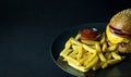 Close up view of gourmet hamburger with french fries and ketchup isolated on black Royalty Free Stock Photo