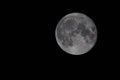 Close-up view of a gray full moon in the black night sky