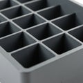 A close-up view of a gray plastic grid tray, featuring 16 square compartments Royalty Free Stock Photo