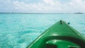 Close up view of green canoe nose surrounded by clystal clear tortoise water. Sunny day at Maldives tropical island. Isolated