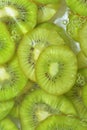 Close-up view of the green kiwi fruit slices in water background. Texture of cooling fruit drink with macro bubbles on Royalty Free Stock Photo