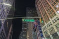 Close up view of green road sign direction West 41st street on skyscrapers and dark night sky background. New York.