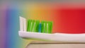 Green tooth brush against colorful background.
