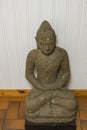 Close up view of grey buddah figure on white wall background