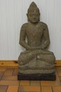 Close up view of grey buddah figure on white wall background