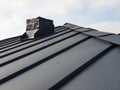 close up view of grey folding roof and chimney on waterproofing layer of house under construction