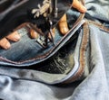 A close up hand is repairing the jeans with an old sewing machine Royalty Free Stock Photo
