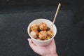 Close-up view of hand holding a delicious fried meatballs in a white bowl. Royalty Free Stock Photo