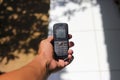 Hand holding an old used cell phone with conventional keypad that were popular in the late 90s and 2000s Royalty Free Stock Photo