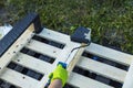 Close up view of hand holding paint roller and treating wooden pallet with special black tree oil Royalty Free Stock Photo