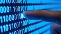 A close-up view of a hand interacting with binary code on a digital screen Royalty Free Stock Photo