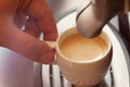 Close up view of the hand of a man working in a coffee house preparing espresso coffee waiting for the coffee machine to finish p