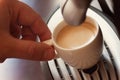 Close up view of the hand of a man working in a coffee house preparing espresso coffee waiting for the coffee machine to finish p Royalty Free Stock Photo