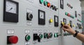 Close Up View of Hand Operating Control Panel Switches with Multiple Gauges and Indicator Lights Royalty Free Stock Photo