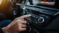 Hand Adjusting Car Radio Controls With Sunlight Glinting On Dashboard driver Royalty Free Stock Photo