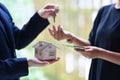Close up view hand of property realtor giving house keys to new owner after signing contract. Real estate, mortgage and Royalty Free Stock Photo