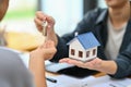 Close up view hand of property realtor giving house keys to new owner after signing contract. Real estate, mortgage and Royalty Free Stock Photo