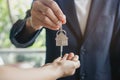 Close up view hand of property realtor / landlord giving key house to buyer / tenant Royalty Free Stock Photo