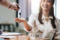 close up view hand of property realtor landlord giving a key house to buyer tenant at modern office. Royalty Free Stock Photo